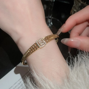 Gros plan d'un bracelet doré avec incrustation de zircon rectangulaire sur un poignet