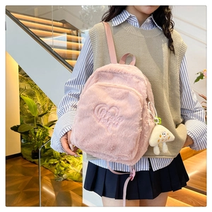 Detailed view of pink plush backpack with heart embroidery and cute mushroom charm