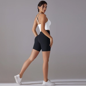 Detail of cross back white sports bra and black high waist seamless yoga shorts set