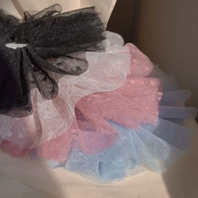 Detail view of layered mesh tulle skirts in black, white, pink, and blue colors