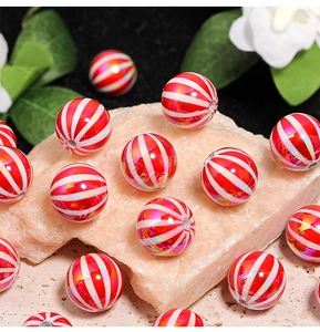 Macro shot of red and white striped pumpkin beads with UV iridescent finish on stone