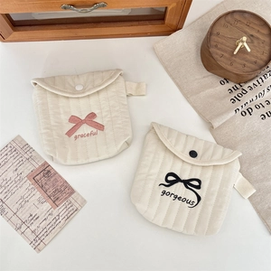 Detail of quilted sanitary napkin pouch with embroidered bows and snap button closure