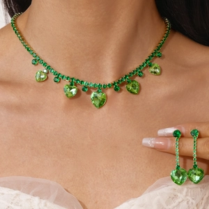 Detail view of heart-shaped green zircon jewelry set on model with necklace and earrings