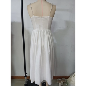 Detail of white dress featuring elegant pearl straps and hidden back zipper closure
