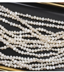 Macro view of white baroque freshwater pearls with natural luster on black tray