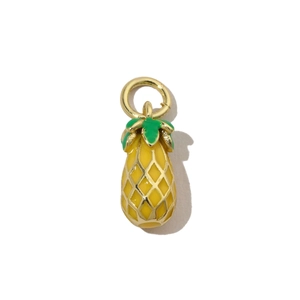 Detail of yellow pineapple pendant with gold-plated edges and green enamel finish