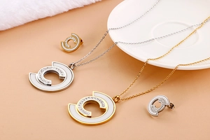 Detailed view of C-shaped jewelry sets with white enamel and sparkling rhinestones