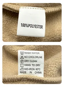 Close-up detail of the care label on khaki fleece fabric showing material and washing instructions