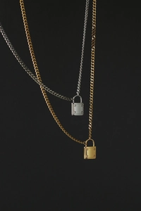 Detail of gold and silver padlock necklaces with studs on chunky cuban chains