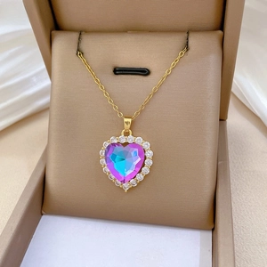 Detail of heart necklace with gradient purple crystal and zircon inlay in a jewelry box