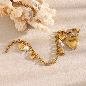 Detailed view of 18K gold plated chain bracelet with heart, sun, pearl, and paw charms