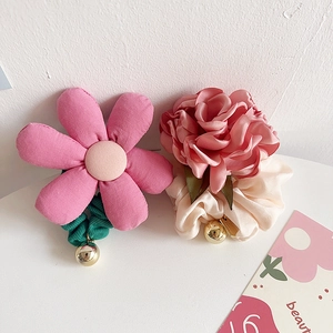 Detailed shot of pink floral hair ties with fabric petals and gold pendant accents