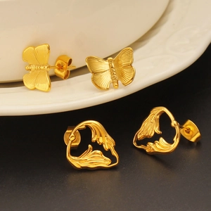 Macro shot of 18K gold plated butterfly and heart shaped studs with textured finish