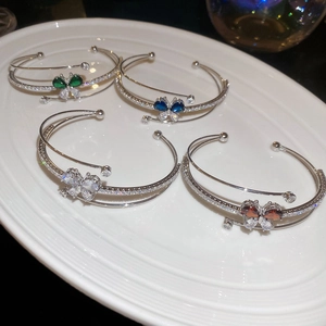 Dettaglio di quattro bracciali a farfalla in zirconi nei colori verde, blu, trasparente e rosso
