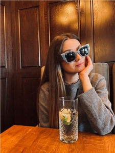 Detail of oversized marble grey sunglasses worn by a model in a trendy urban fashion setting