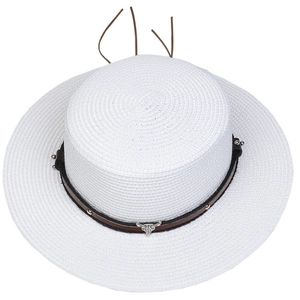 Detail of white straw hat featuring a black leather band and silver bull head pendant