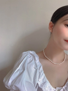 Close-up of model wearing baroque freshwater pearl necklace and matching stud earrings