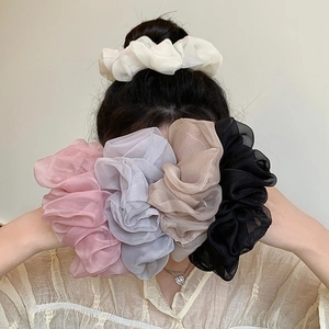 Detailed close-up of large organza hair scrunchies in five elegant pastel colors