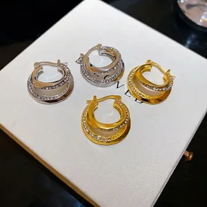 Sparkling double-layered crystal hoop earrings in gold and silver finish on a box