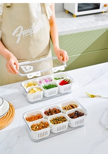 Detail of transparent storage box with six compartments for draining ginger and garlic