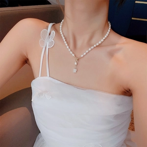 Detail of freshwater pearl necklace with lily of the valley pendant on a model
