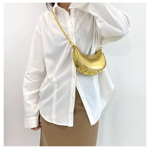 Detailed view of golden metallic crescent bag with CAMPI lettering and chain strap