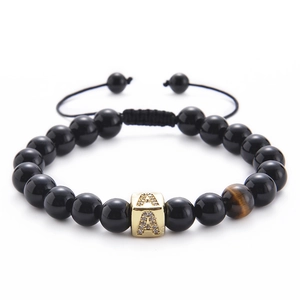 Detail of beaded bracelet with black agate, tiger eye stone, and golden letter A charm