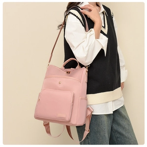 Soft pink nylon backpack worn over one shoulder featuring sleek metal zipper details