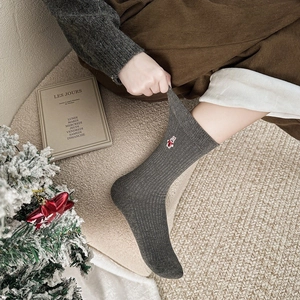 Texture de maille détaillée de chaussettes gris foncé avec broderie lapin mignon