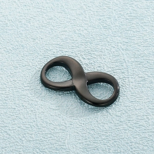 Macro di un ciondolo a forma di infinito in acciaio inossidabile nero su fondo blu