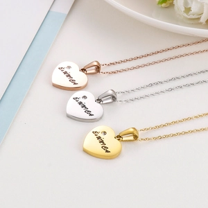 Macro shot of heart-shaped pendants in gold, silver, and rose gold with zircon stones
