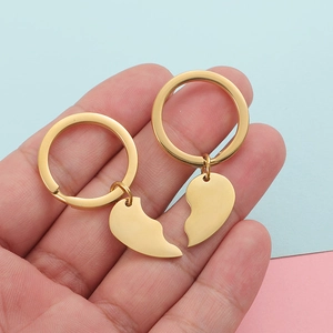 Polished gold stainless steel heart keychain set for couples in hand view
