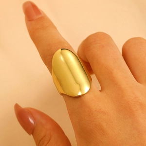 Detailed view of polished gold wide shield ring in irregular geometric stainless steel style