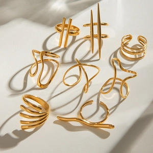 Minimalist gold geometric irregular rings with polished 18K gold finish on stone background