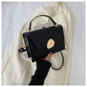 Détail du sac à main noir en cuir PU avec boucle dorée et bandoulière amovible
