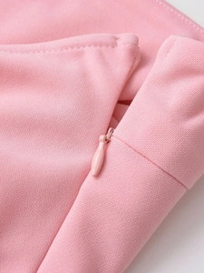 Detailed close-up of the pink fabric texture and concealed zipper on the asymmetric top