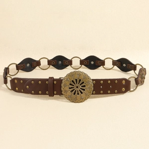 Détail d'une ceinture bohème en cuir marron avec boucle florale évidée et rivets