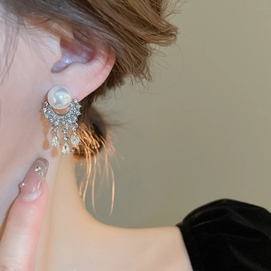 Detail of pearl tassel earrings featuring zircon crescents and teardrop crystal pendants