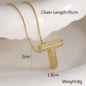 Detailed view of a gold-plated T-letter pendant necklace set with sparkling zircons