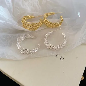 Textured gold and silver twisted C-shape hoop earrings with a woven vintage design