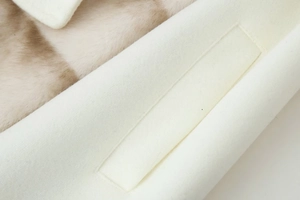 Detailed close-up of cream wool jacket featuring soft faux fur lining and premium stitching