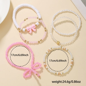 Detail of pink beaded bracelet set with size labels and bow charm on beige background