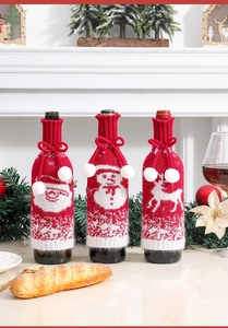 Close-up of three knitted Christmas wine bottle covers with Santa, Snowman and Reindeer