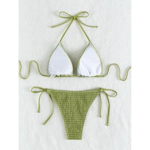 Green smocked halter bikini set with side-tie high waist bottoms on white fabric