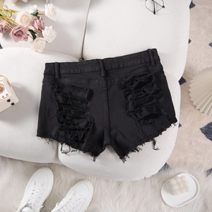 Detail of high-waist black denim shorts with heavy distressed back and raw fringe hem