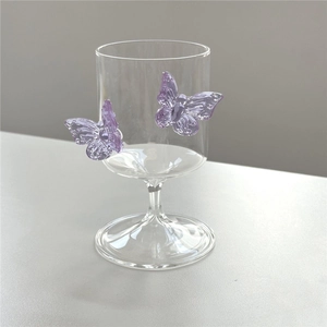 Detailed close-up of high borosilicate champagne glass with 3D purple butterfly accents