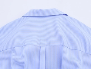 Detail of the back yoke and box pleat on a blue striped long sleeve cotton shirt