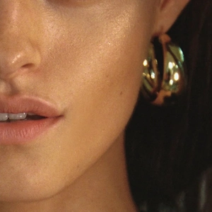 Minimalist 18k gold plated stainless steel C-shape hoop earrings worn by a model
