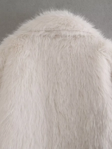 Dettaglio ravvicinato della texture in ecopelliccia e del colletto del cappotto beige