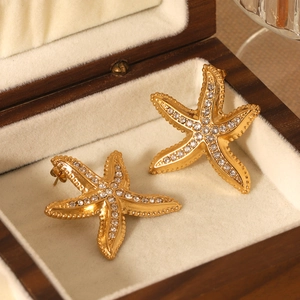 Sparkling gold starfish stud earrings inlaid with white zircon in a luxury wood box